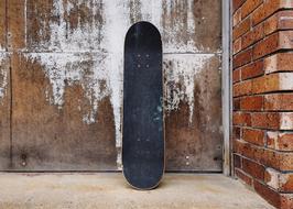 Skateboard and brick wall