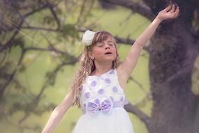 little girl in a beautiful dress in nature on a blurred background