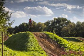 motocross, biker in jump over hill