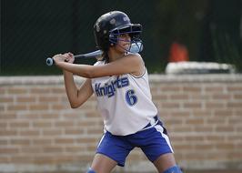 girl with a bat in her hands playing softball