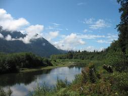 Beautiful landscape with the river, among the colorful mountains with trees, with clouds in Washington State, USA