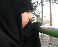 Muslim girl in black clothes near the trees in Iran
