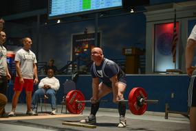 Weights Lifting, muscular man with barbell in gym