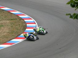 Valentino Rossi and Alvaro Bautista, on the colorful racing bikes, on the road, on the competition