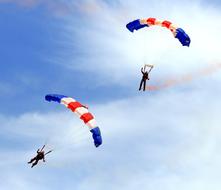 Paragliding, two persons on striped Parachutes at Sky