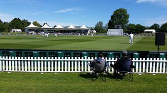 two persons looking at Cricket game