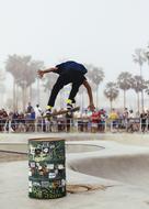 young Man on Skateboard jumps over barrel