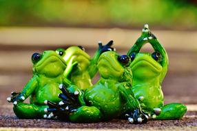 Figures of the green frogs doing yoga
