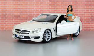 Model of a girl, near the model of the beautiful, shiny, white "Mercedes Sl 65 Amg" car, near the brick wall