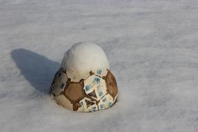 Colorful soccer ball in beautiful, white snow, with the shadow, in light