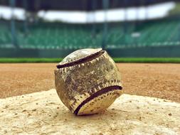 dirty baseball ball on the field, close-up