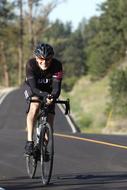 a man on a bicycle rides on the road during a race