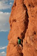 climber on Owl Rock in Arches National Park, USA