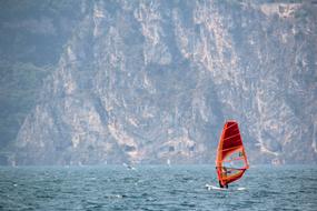 red sailboat on lake garda