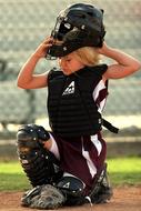 Blonde female softball catcher player, on the field, on the competition