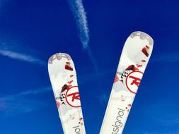 white mountain skis on a bright blue sky background on a sunny day