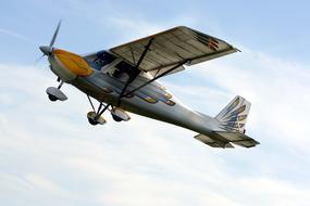 light plane with a propeller in the sky, bottom view