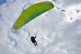 Paraglider beneath green Wing at sky
