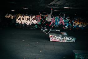 skateboarder in a dark room with graffiti