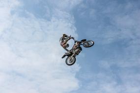 stunt motorcyclist high in the sky against the backdrop of clouds