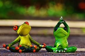 Cute, green and yellow figures of frogs, doing yoga