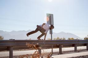 the guy with the skateboard jumps over the fence on the track