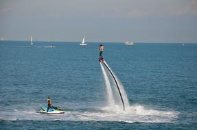 man riding a flyboard at sea