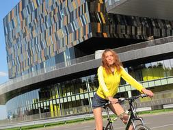 Girl on the bike, near the colorful building in Skolkovo, Moscow, Russia