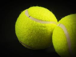tennis balls close up on black background