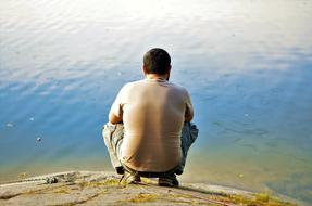 pensive man near quiet water