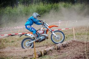 Side view of the rider, on the colorful motorcycle, near the green plants