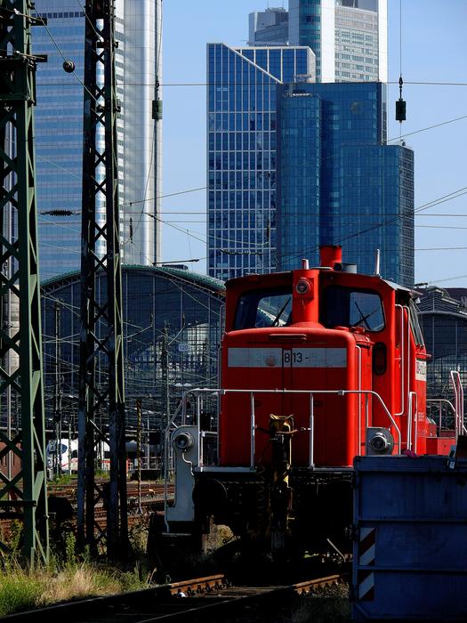 red locomotive in modern city