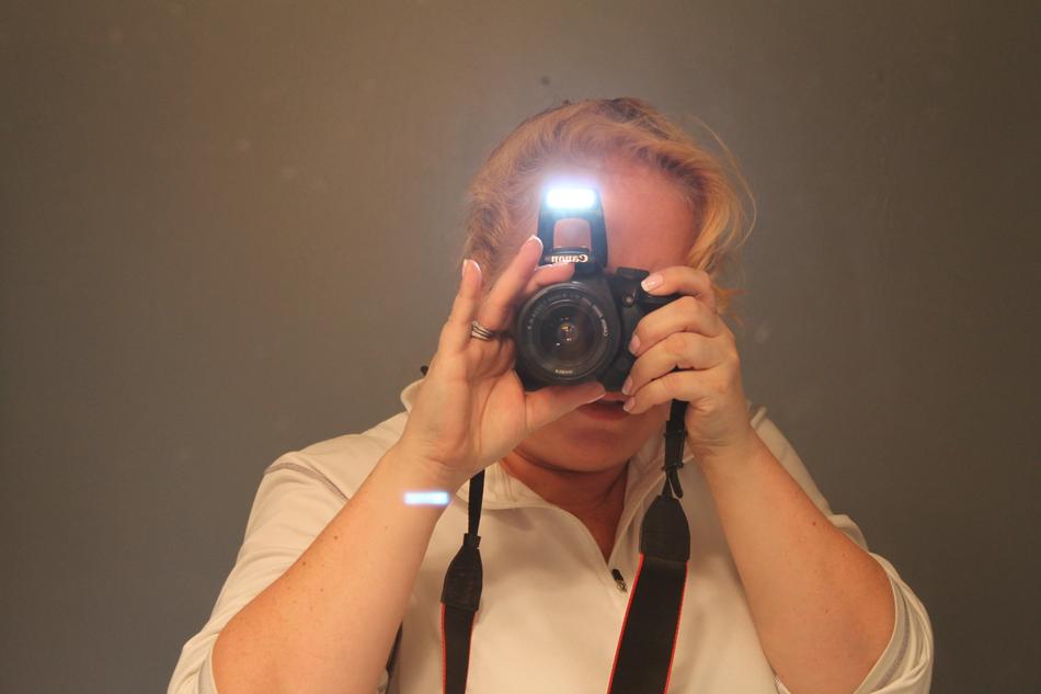 Blonde woman, taking a photo with the camera, with the flashlight