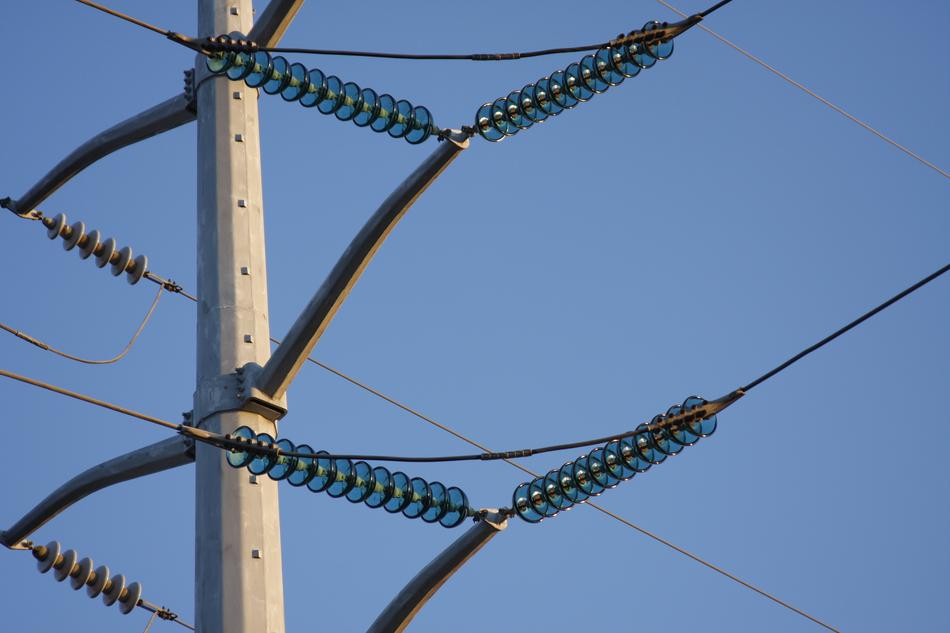 Close-up of the power lines, with the blue glass, at blue sky on background