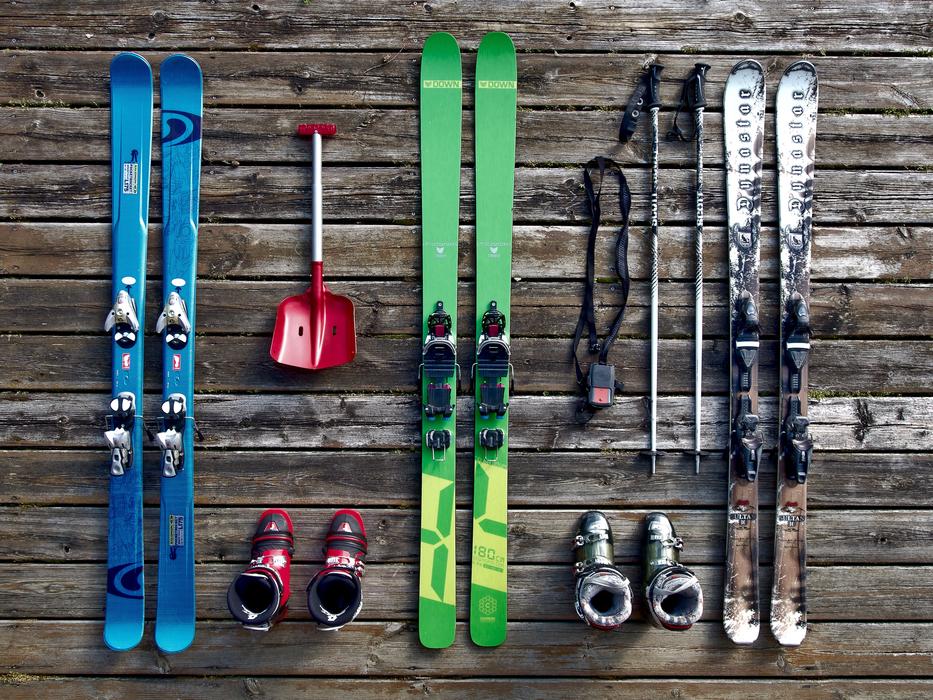 Colorful skis, shoes and other tools, on the wooden surface in winter