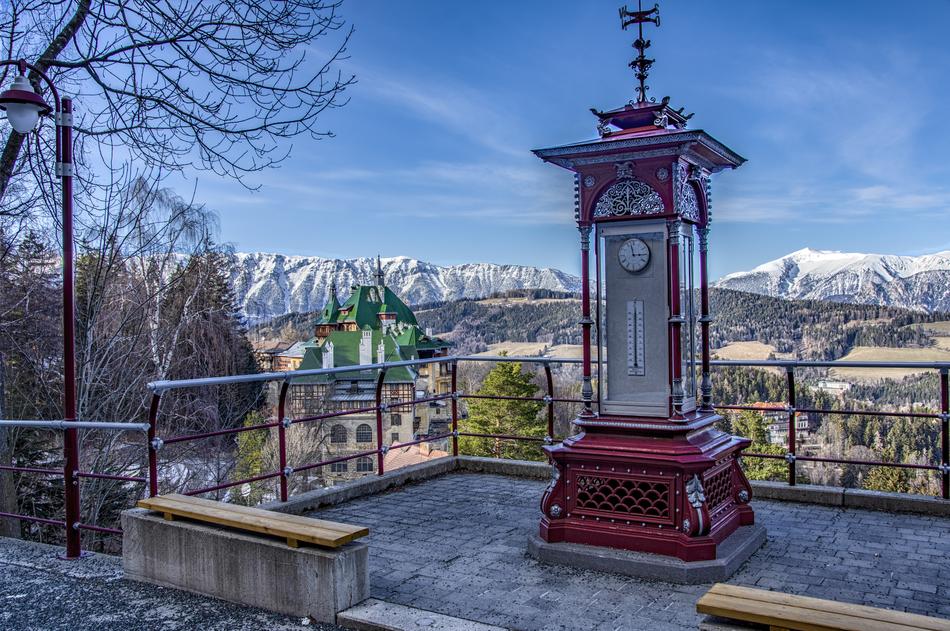 photo of street clock against the background of the Alpine mountains
