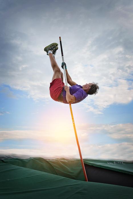 Pole Vaulting man on background with the light