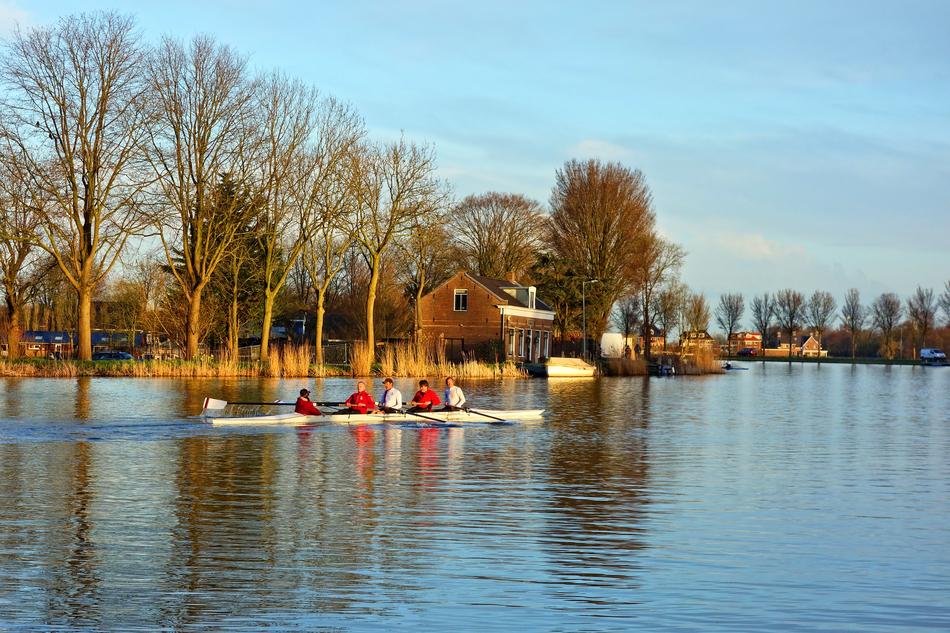Canoe in the river, near the beautiful shore with trees and house