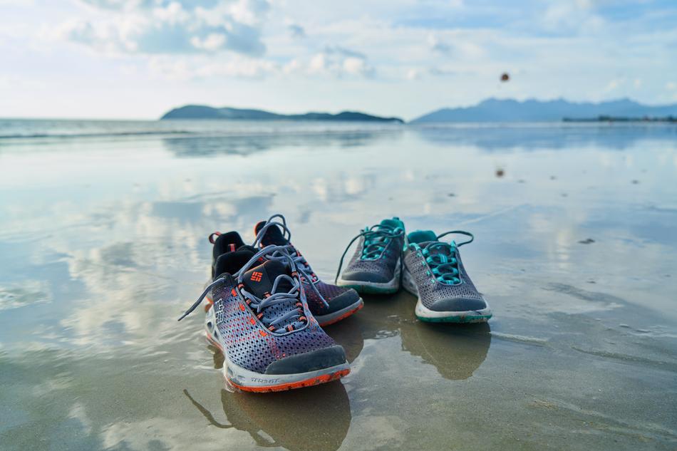 sports shoes in the water on the coast close up