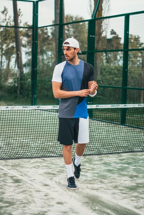 young man walking in front of tennis net