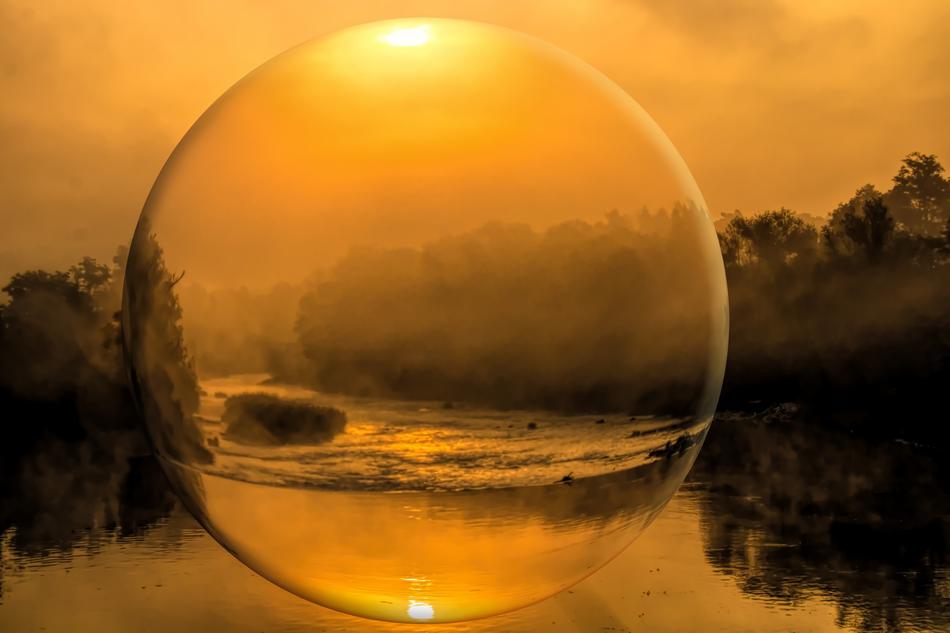 Beautiful view of the river, among the forest in the glass ball, with the colorful sunrise
