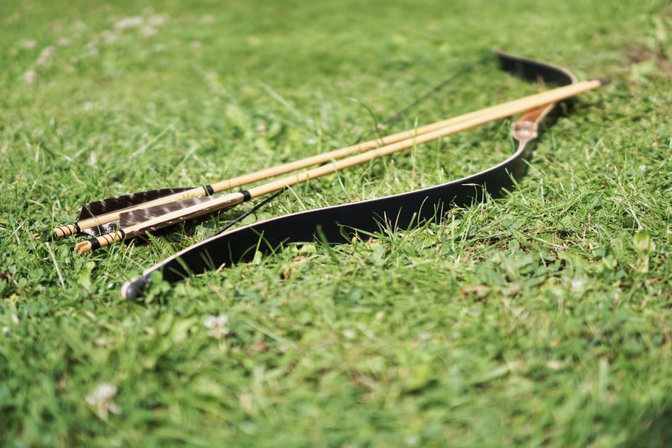 bow with arrows on green grass in blurred background