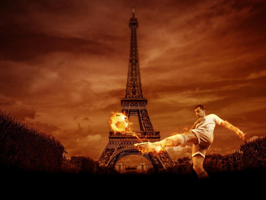football player with a burning ball against the background of the eiffel tower