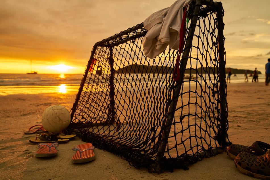 soccer goal on the beach during sunset