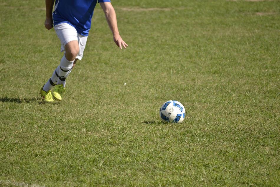 person runs on pitch to football