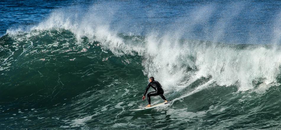 surfer rolls on a wave on the seashore