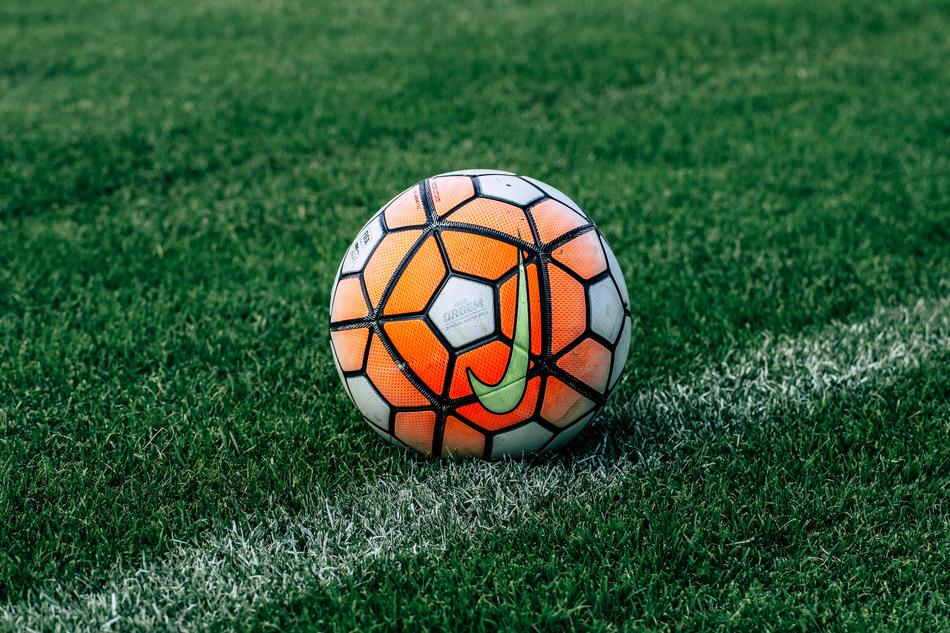 orange and white soccer ball on the lawn