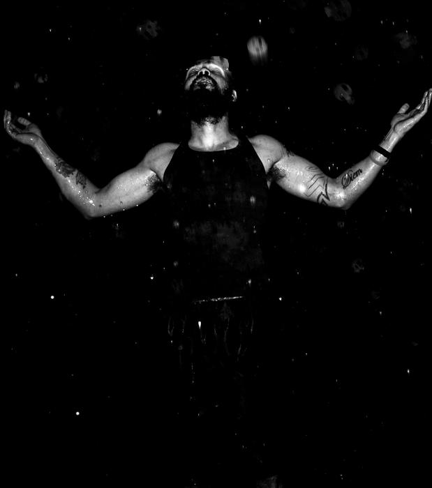 portrait of a sporty man in the rain in the dark