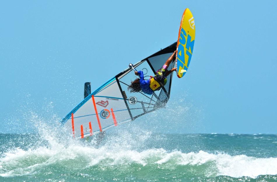 Person on the colorful sailing boat, on the colorful water with waves