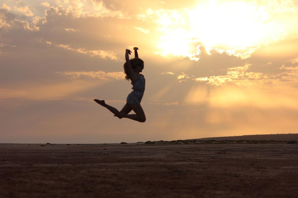 girl jumping in a dance over the plain in the evening in Cape Verde